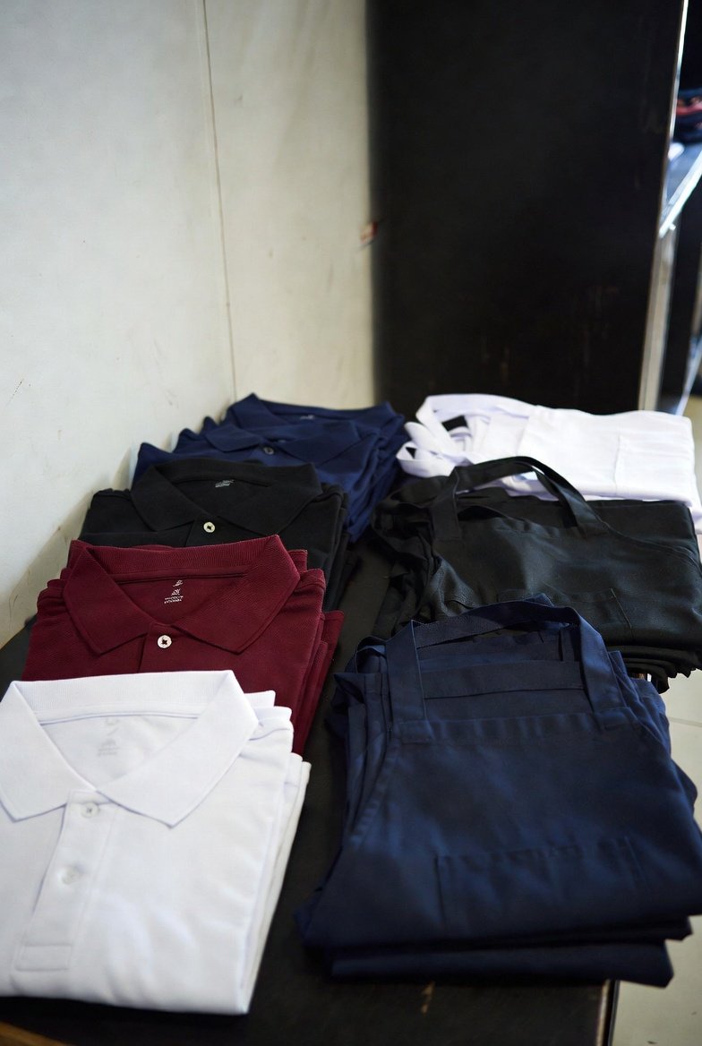 Folded plain polos and aprons for uniforms
